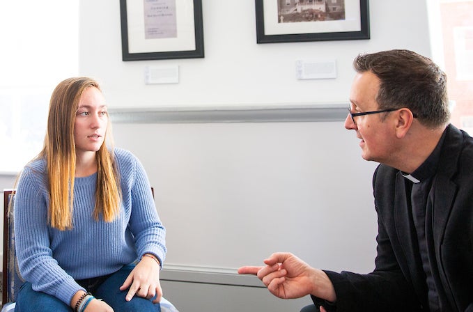 Father Bosco speaks to a student