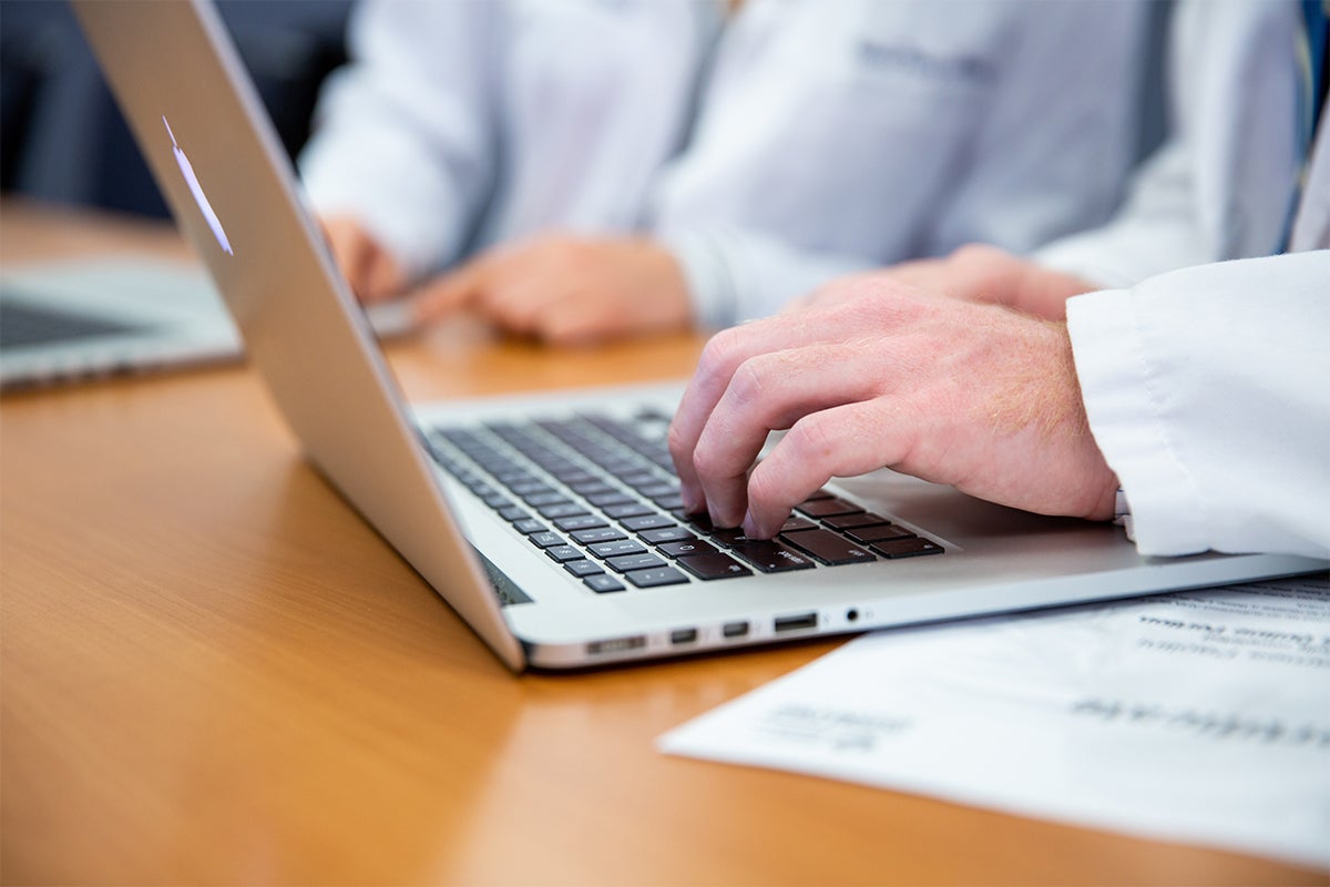 Students work at a laptop