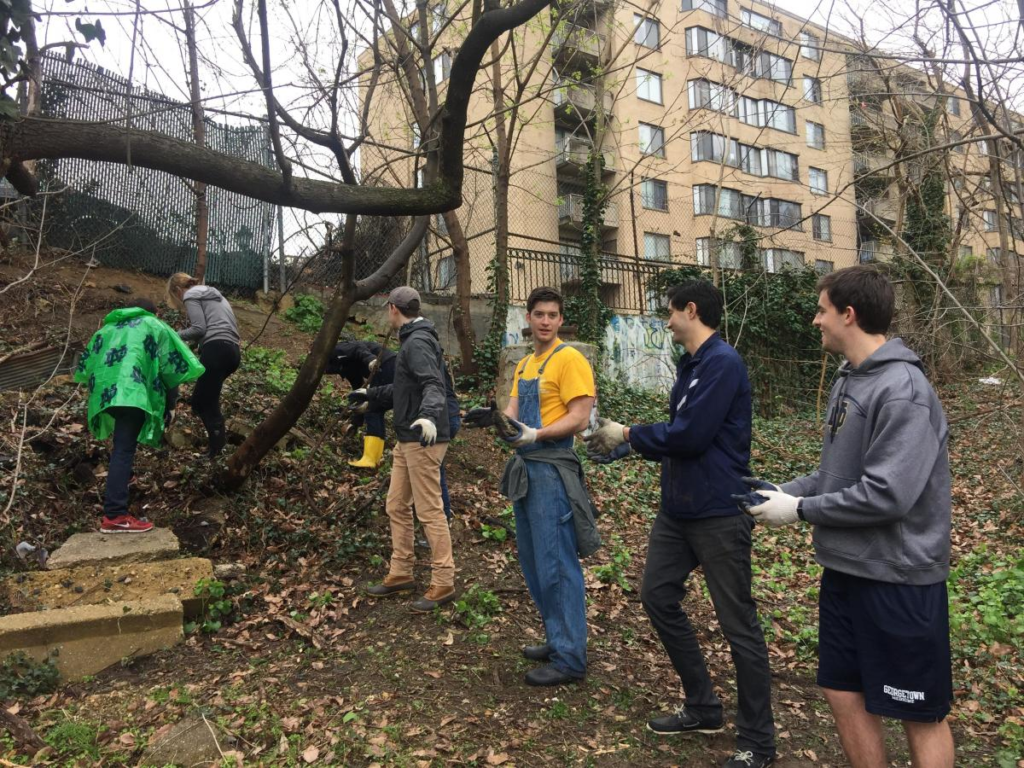 Students clear debris from a vacant lot in the city