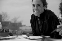 A smiling volunteer sits at a table