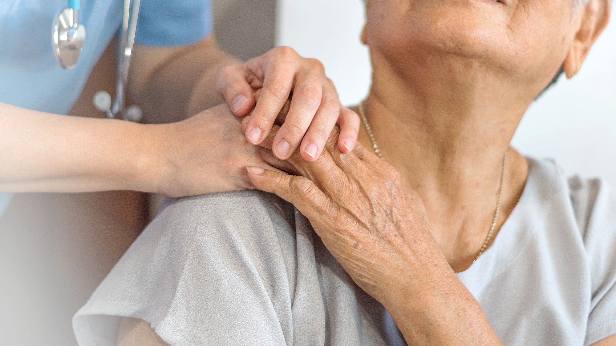 A closeup view of a medical professional comforting a patient