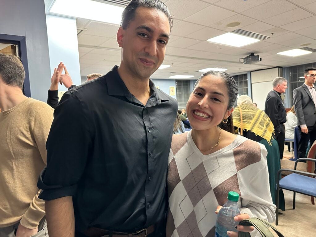 A mentor and mentee stand together