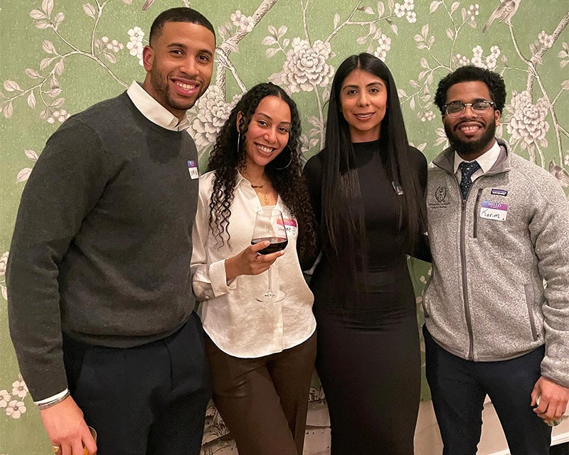 Four individuals stand together at networking night