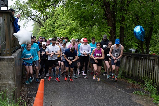 IronMed runners gather at the starting line on a paved running path
