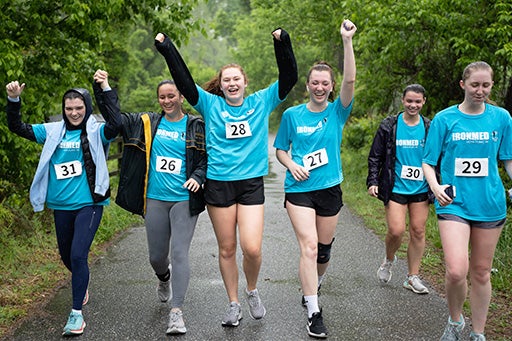 A group of IronMed runners wave their arms in celebration