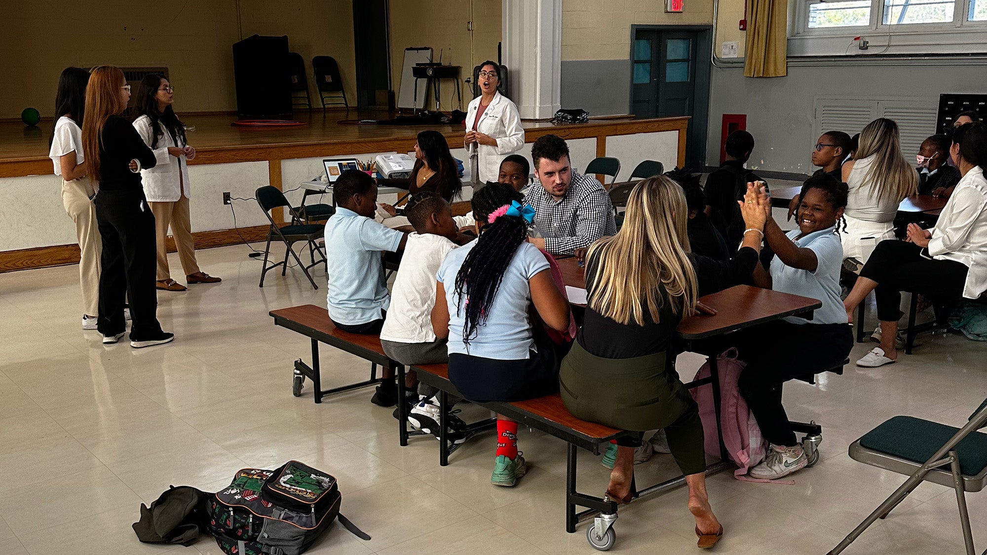 Several medical students teach and oversee a group of school children