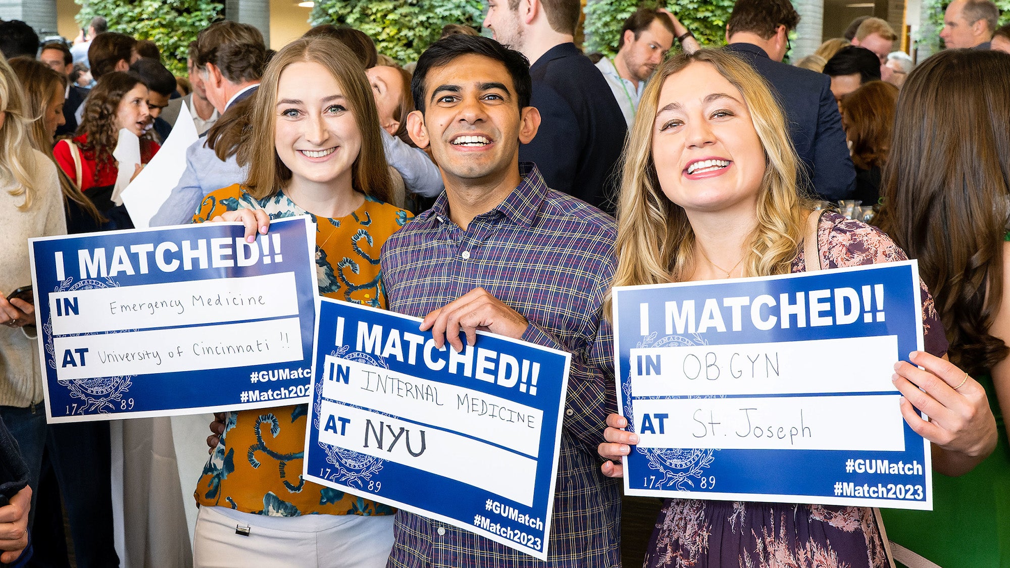 Three students hold signs that read I Matched