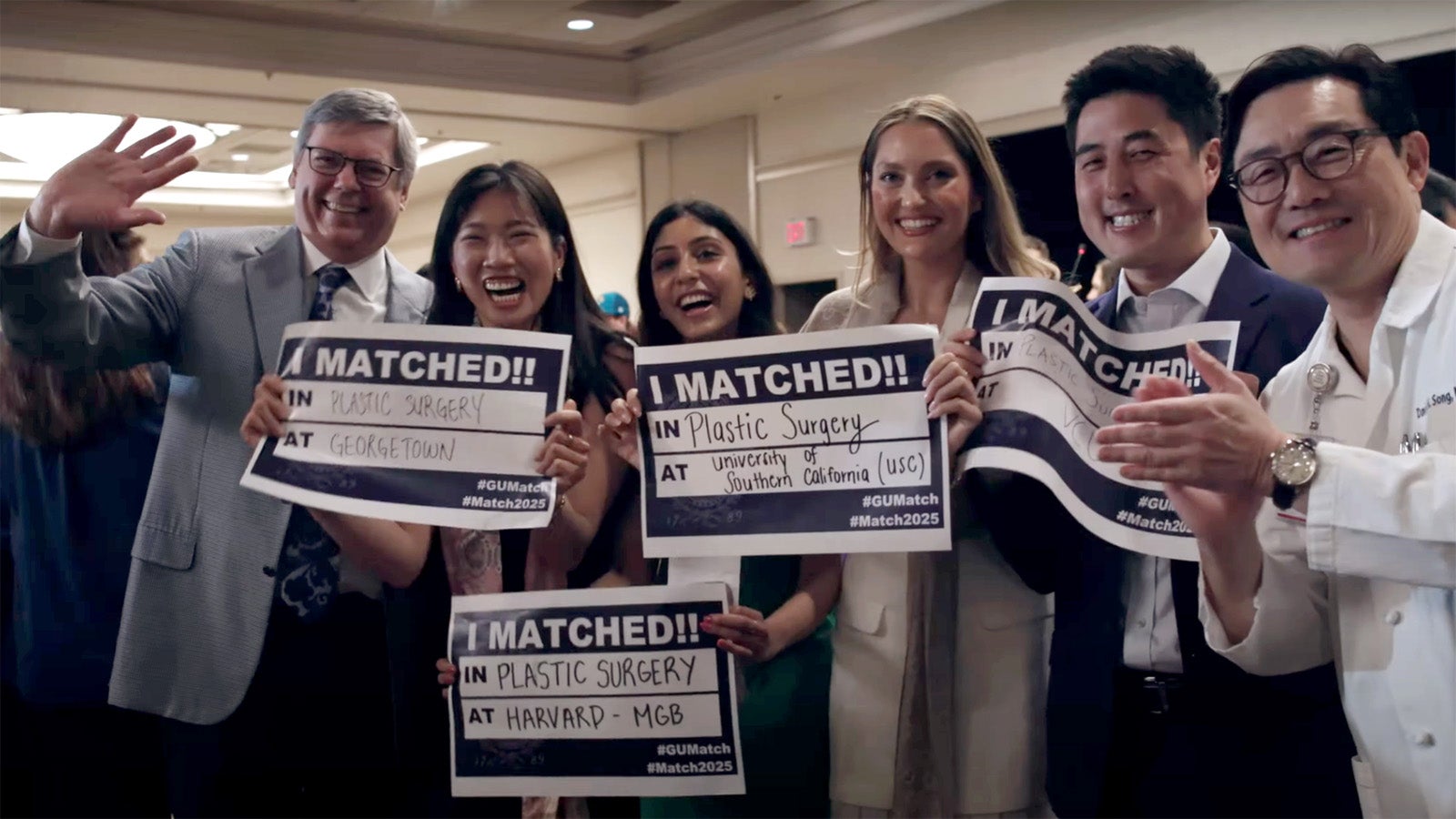 Medical students and faculty stand together holding signs and celebrating on Match Day