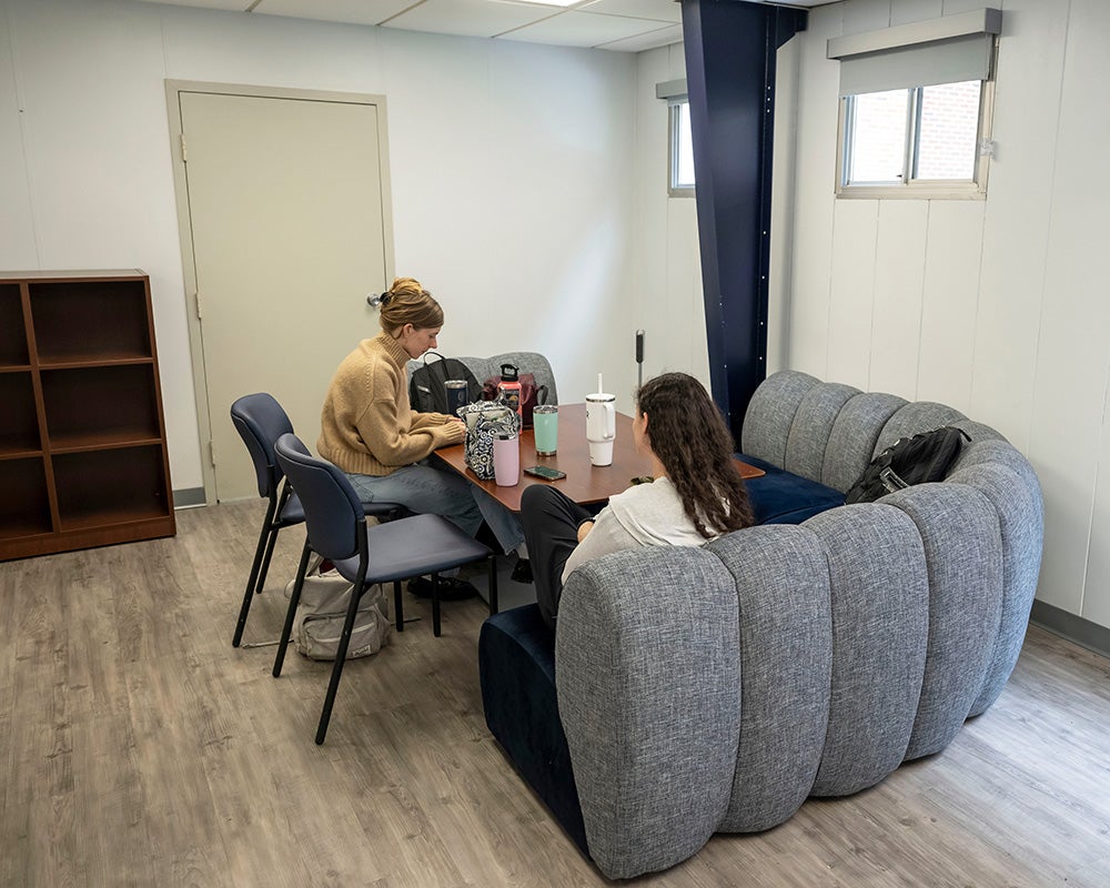 Two students sit at a table in the annex study space