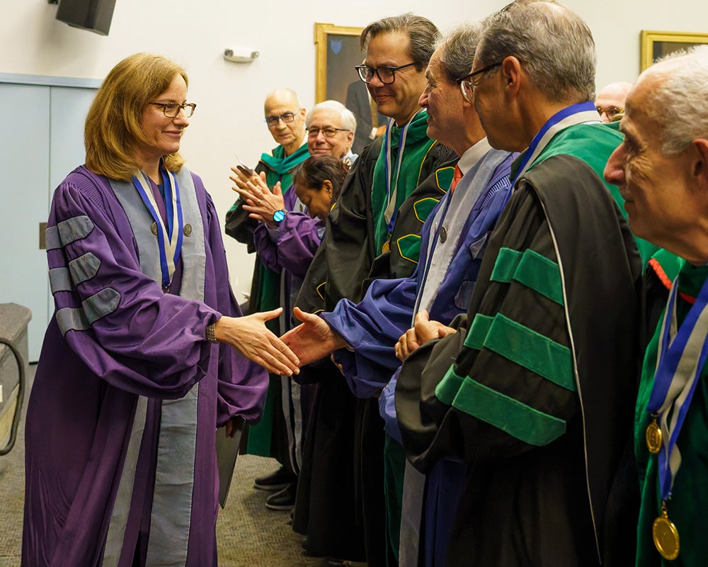 Stacey Kaltman shakes hands with MAGIS members