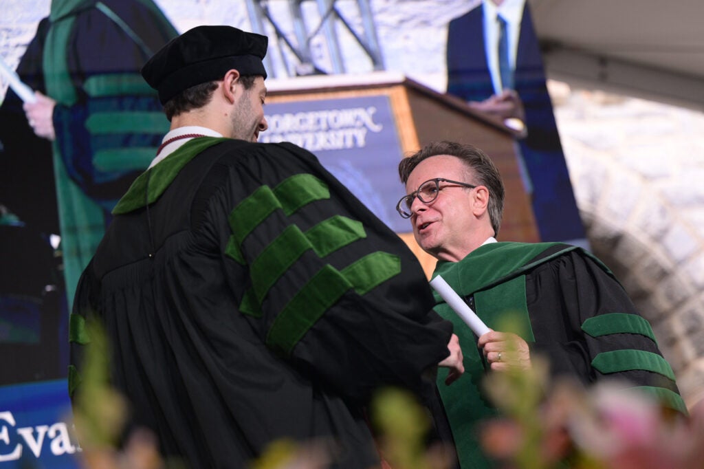 Norm Beauchamp presents a student with his diploma