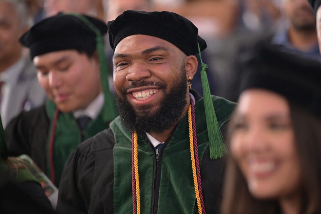 A Black student smiles amid other students in the crowd