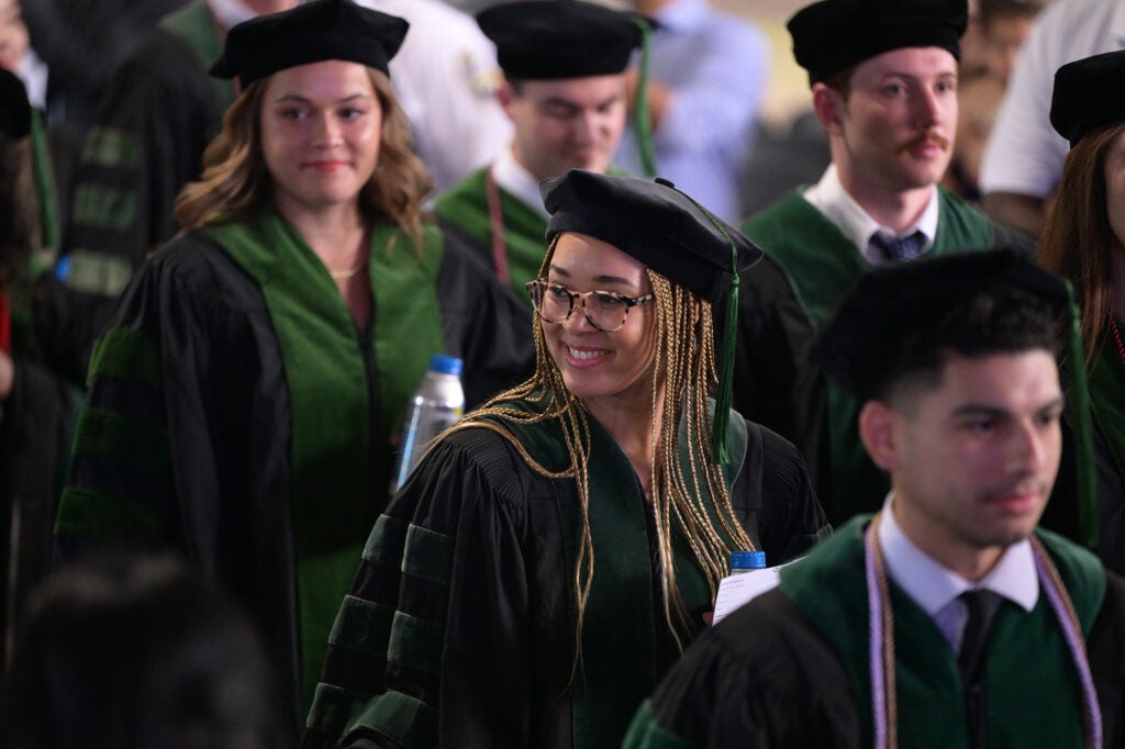 Students walk into the commencement tent