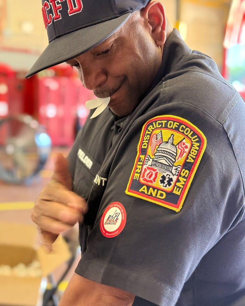 A firefighter puts a sticker on his sleeve