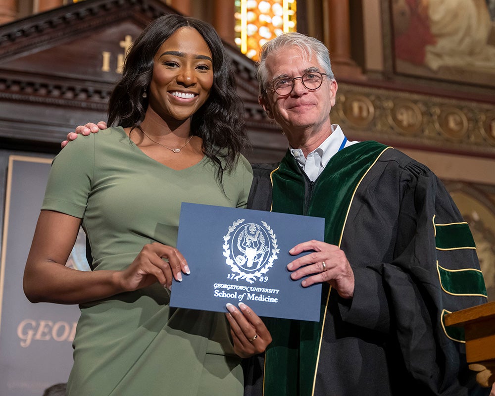 Tami Alade stands with a faculty members
