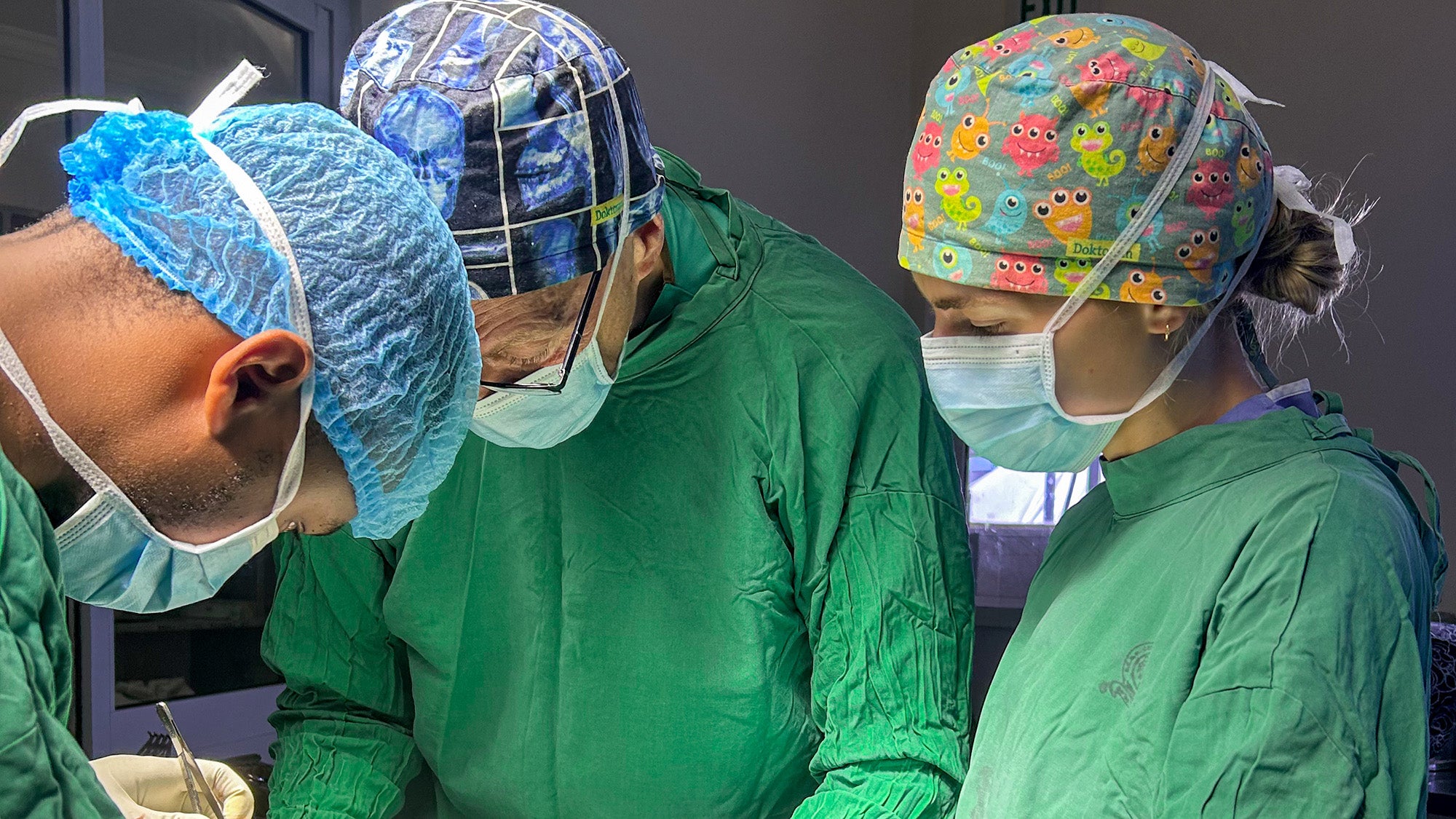 Carlynn Winters looks on as her father and another surgeon operate in a hospital in Africa