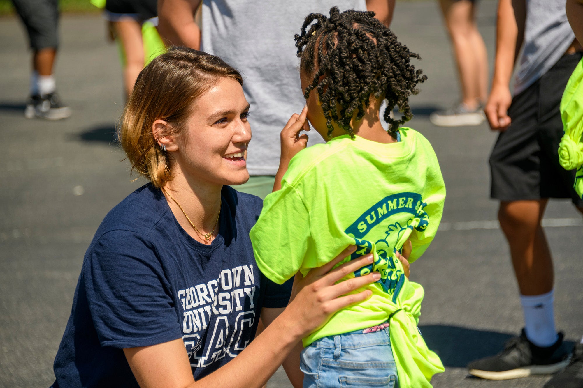 A med student addresses a young camper during the Hoya Summer Sports Camp