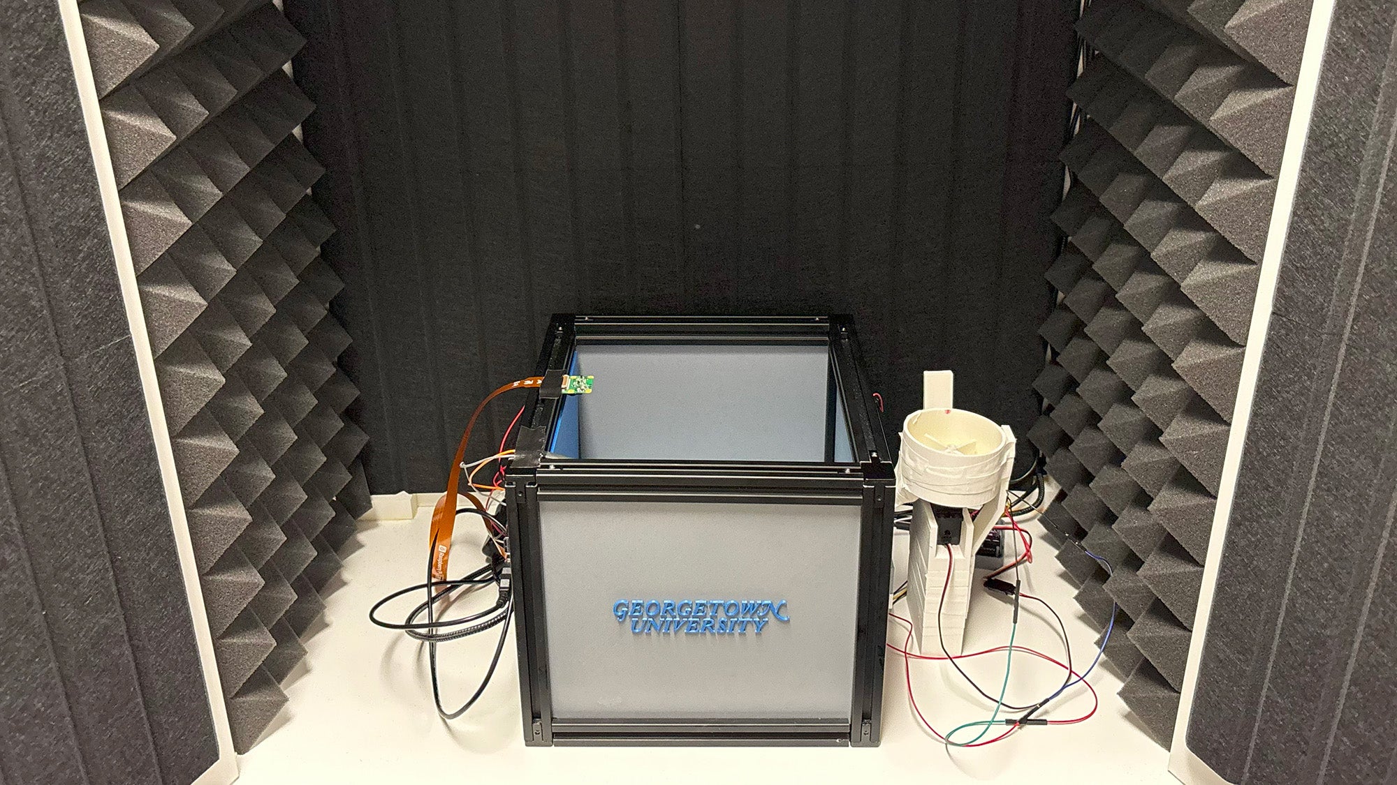 A device with a large box sits in an anechoic chamber