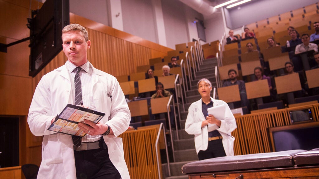 Two students stand in Proctor Harvey auditorium
