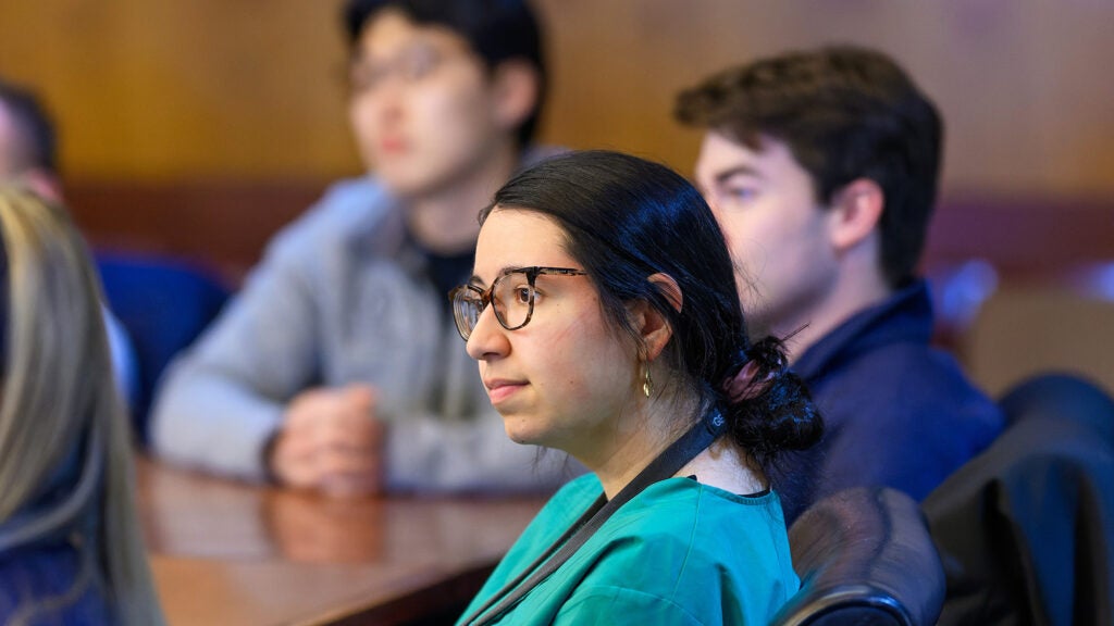 A student listens while seated in a conference room