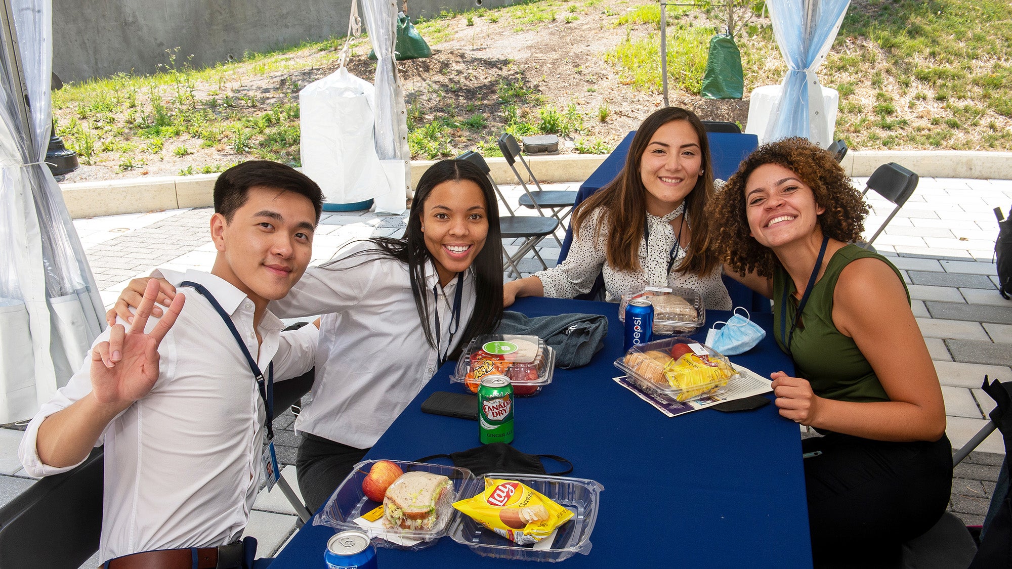 New medical students have lunch togetherin an outdoor tent at student orientation