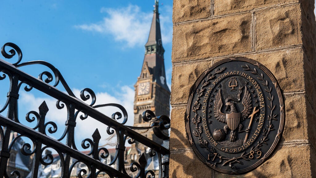 Healy gate and GU Seal in bronze are in the foreground while Healy clocktower is visible in the background