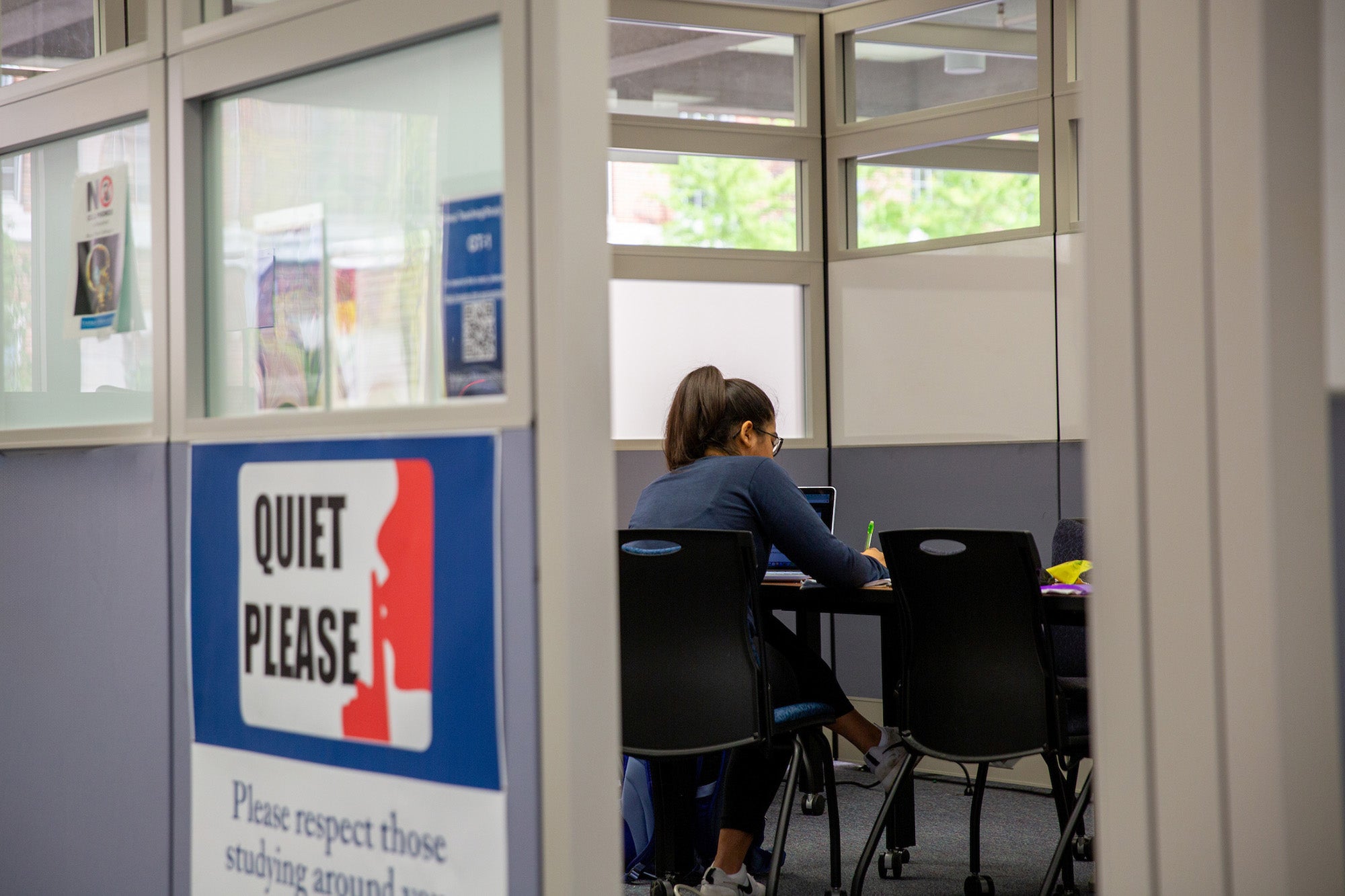 A student studies alone in a study room in DML