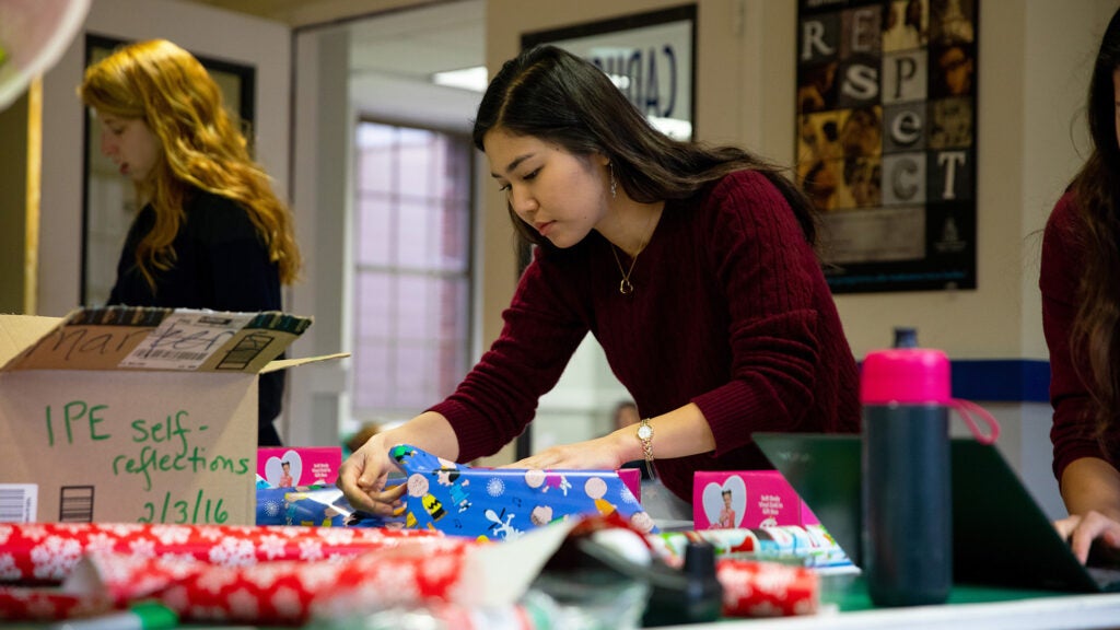 A medical student wraps a present for charity