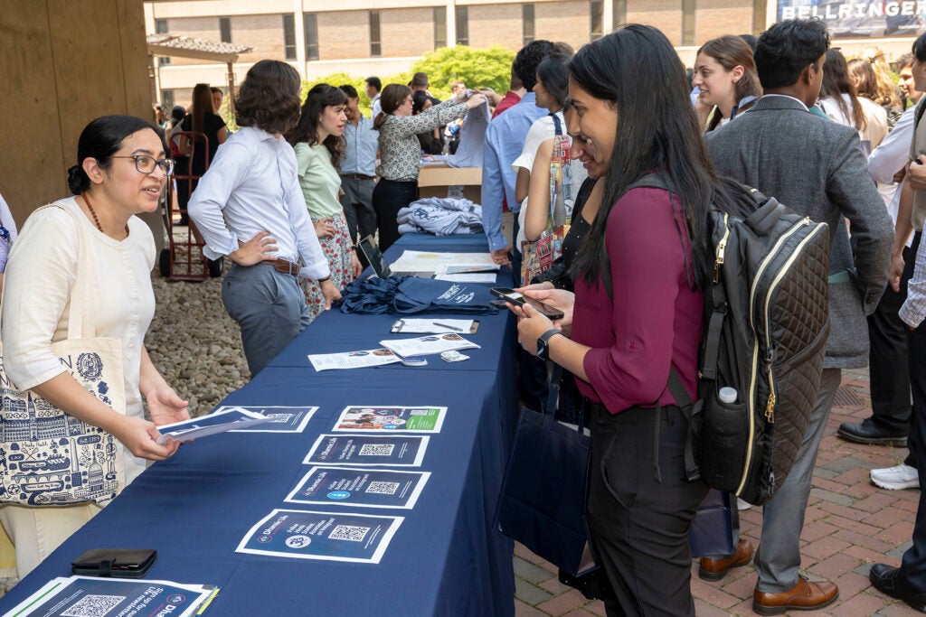 Student representatives of faith groups hand out flyers at a student picnic