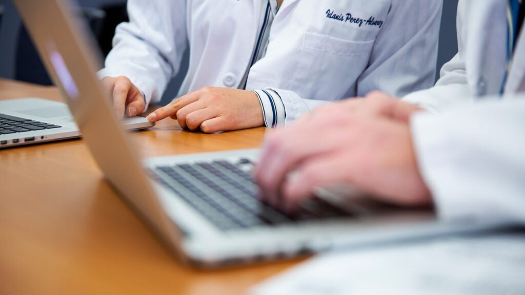 The hands of medical students can be seen using laptop computers