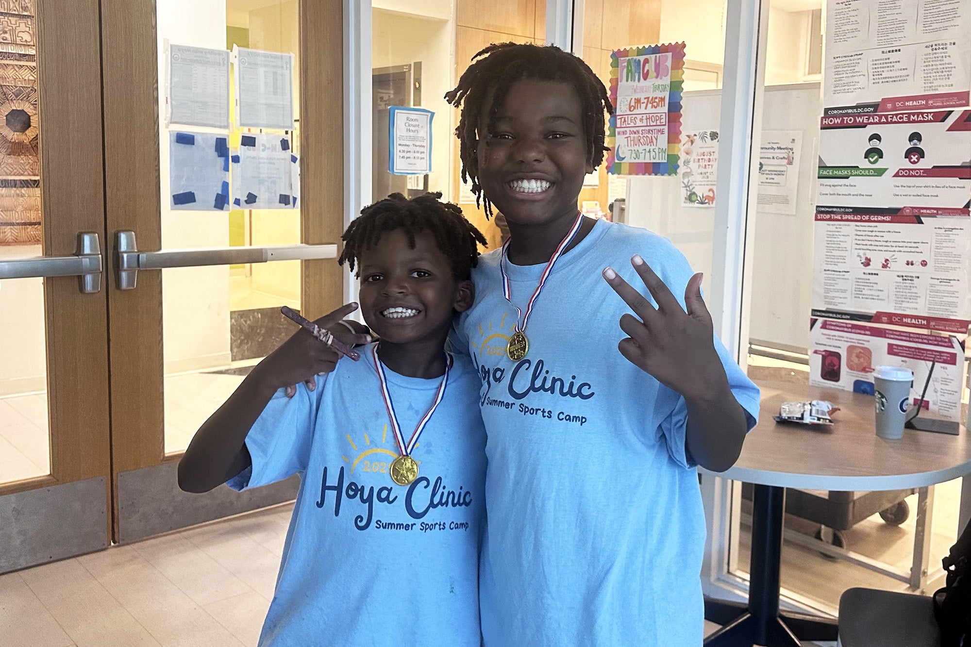Two camper in Hoya Clinic t-shirts stand together
