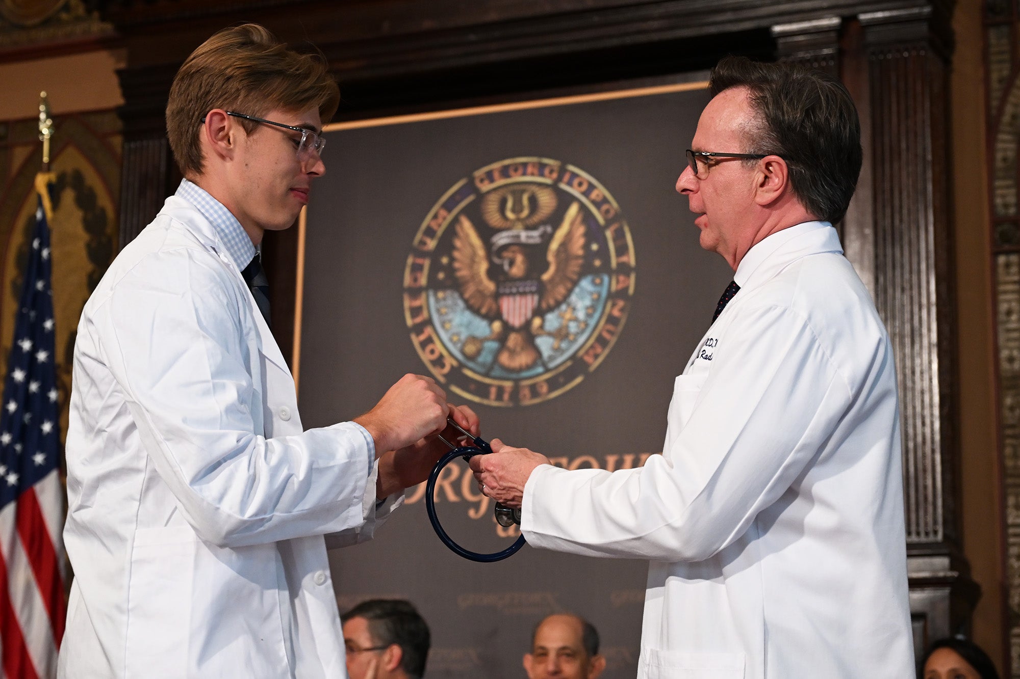 Dr. Beauchamp hands a stethoscope to a student