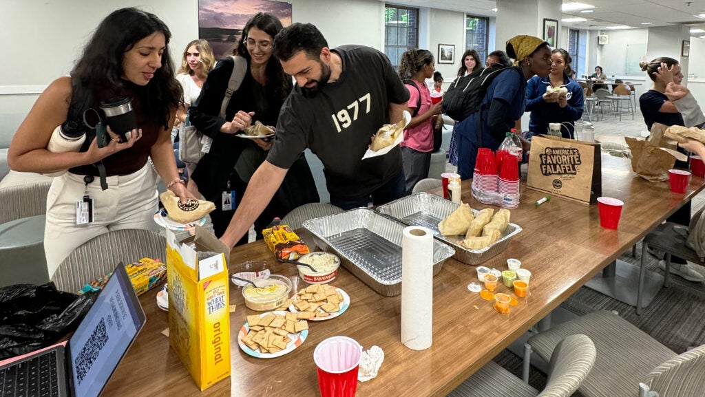 Students crowd around a table filled with food items