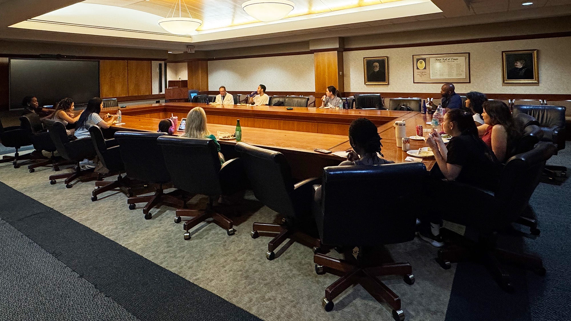 Students sit around a large conference table