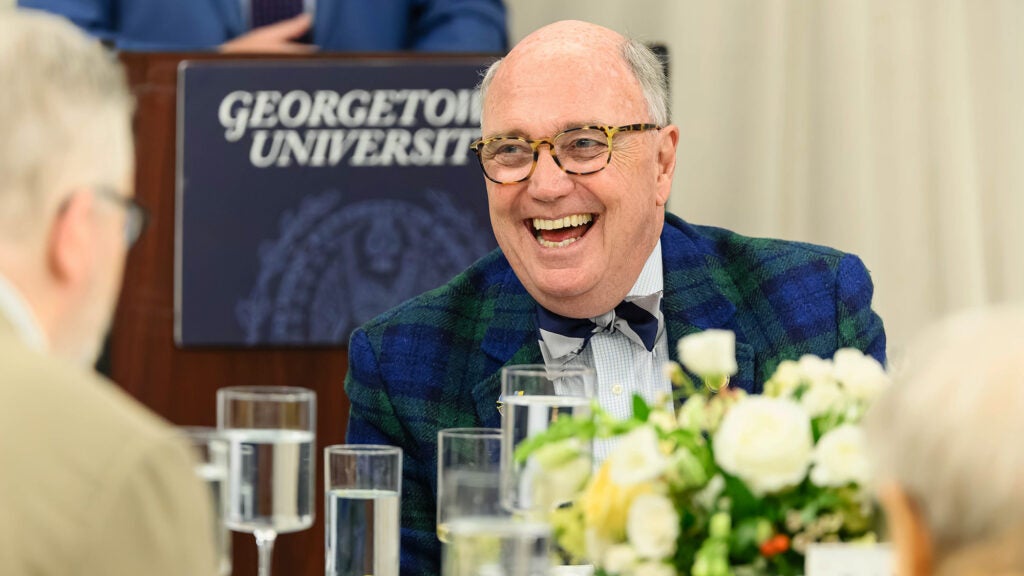 Dr. Mitchell laughs while seated at a table at a scholarship event