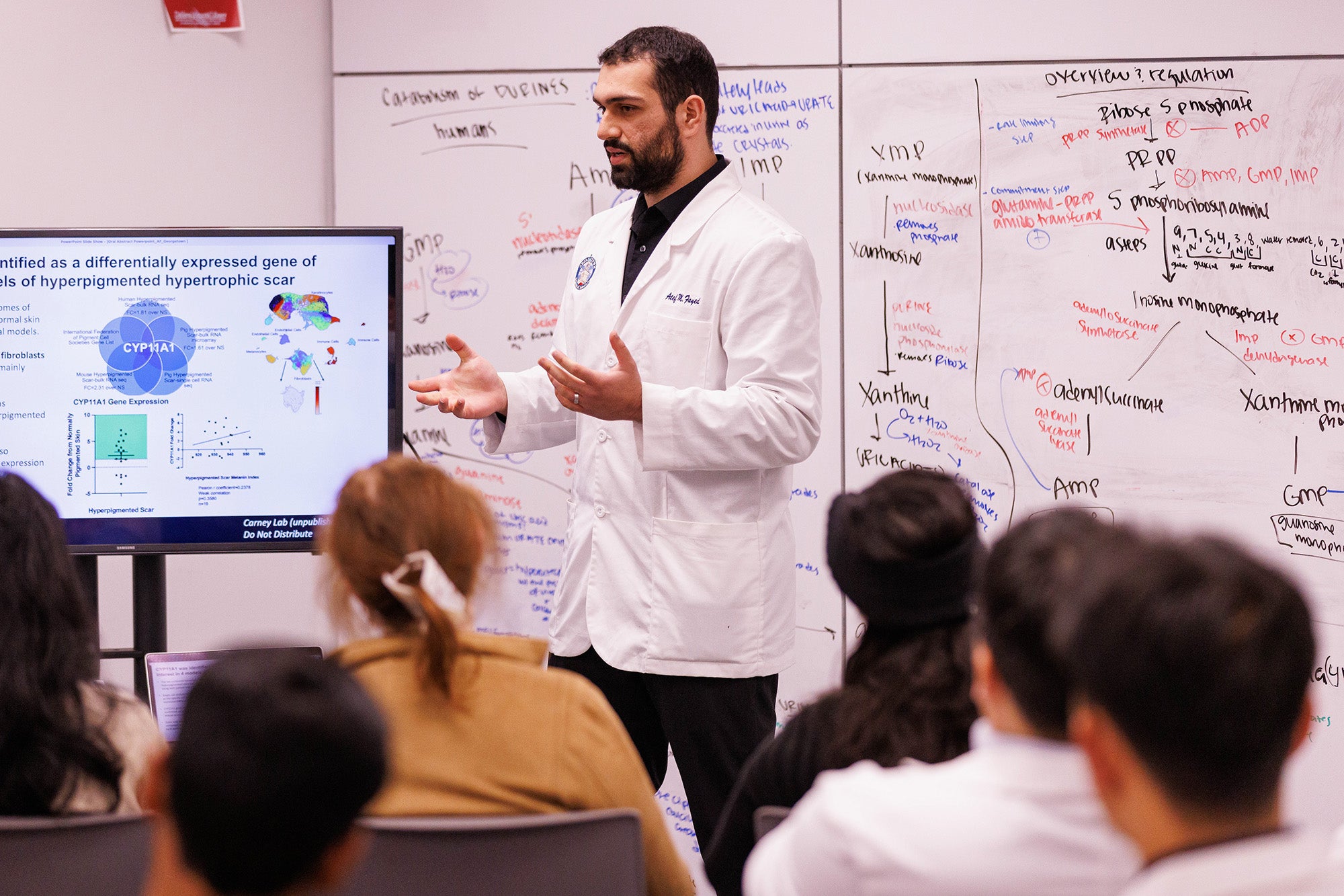A medical student gives a presentation before an audience
