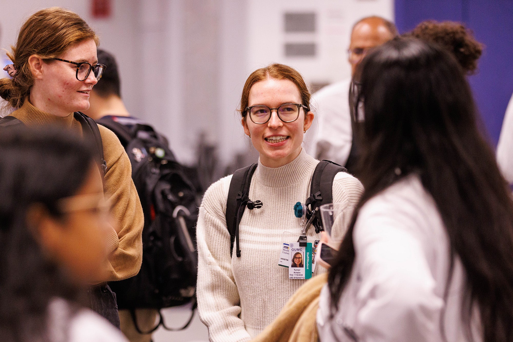 Several medical students stand together and chat