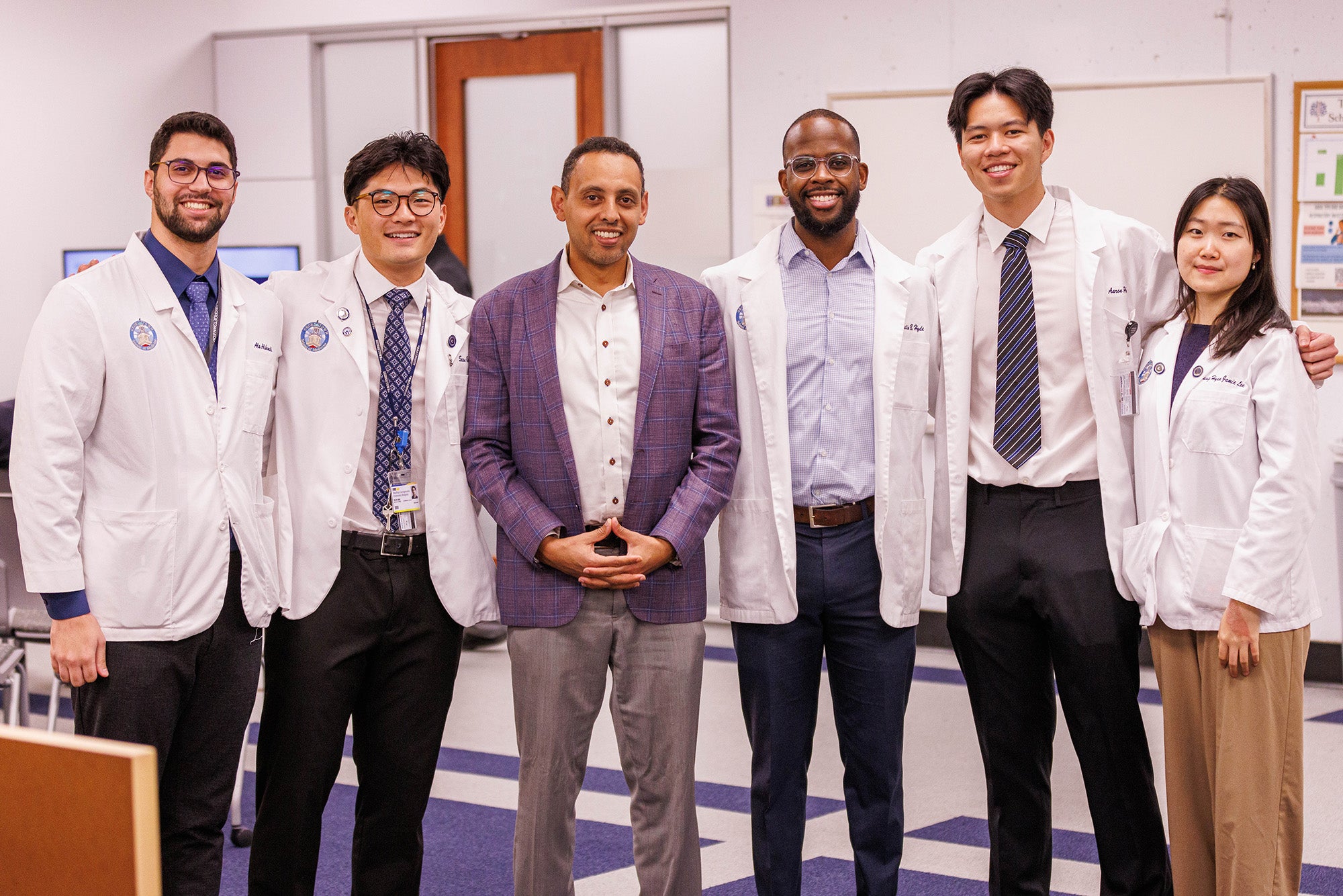 Six individuals stand together