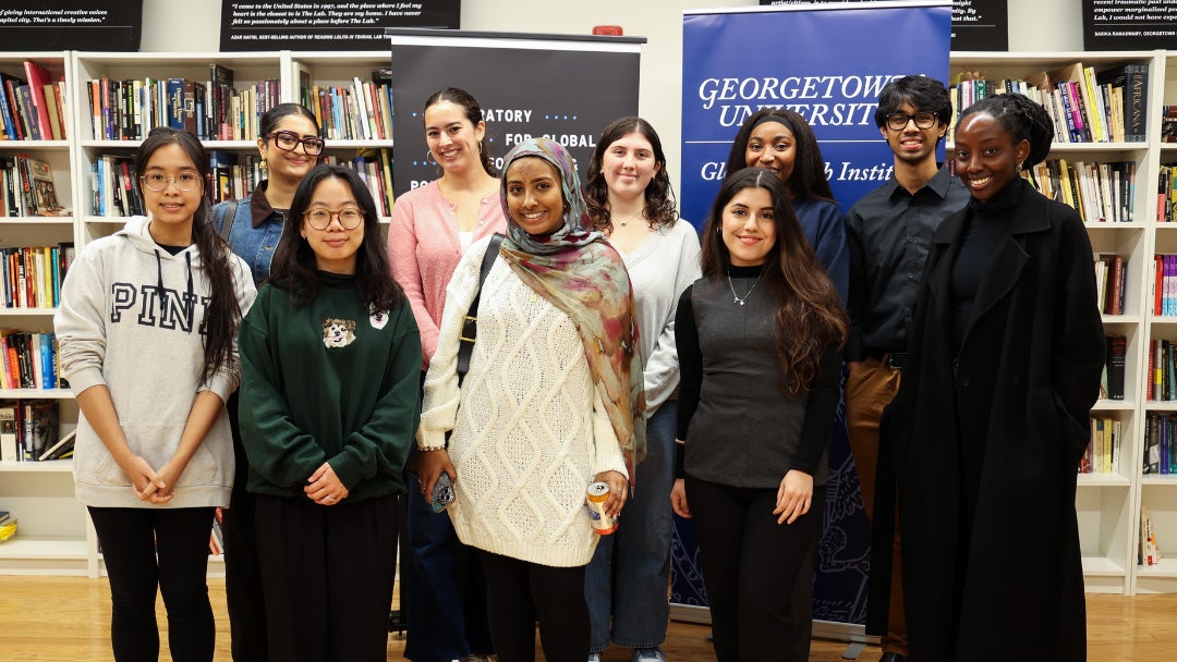 A group of students stand together in the library