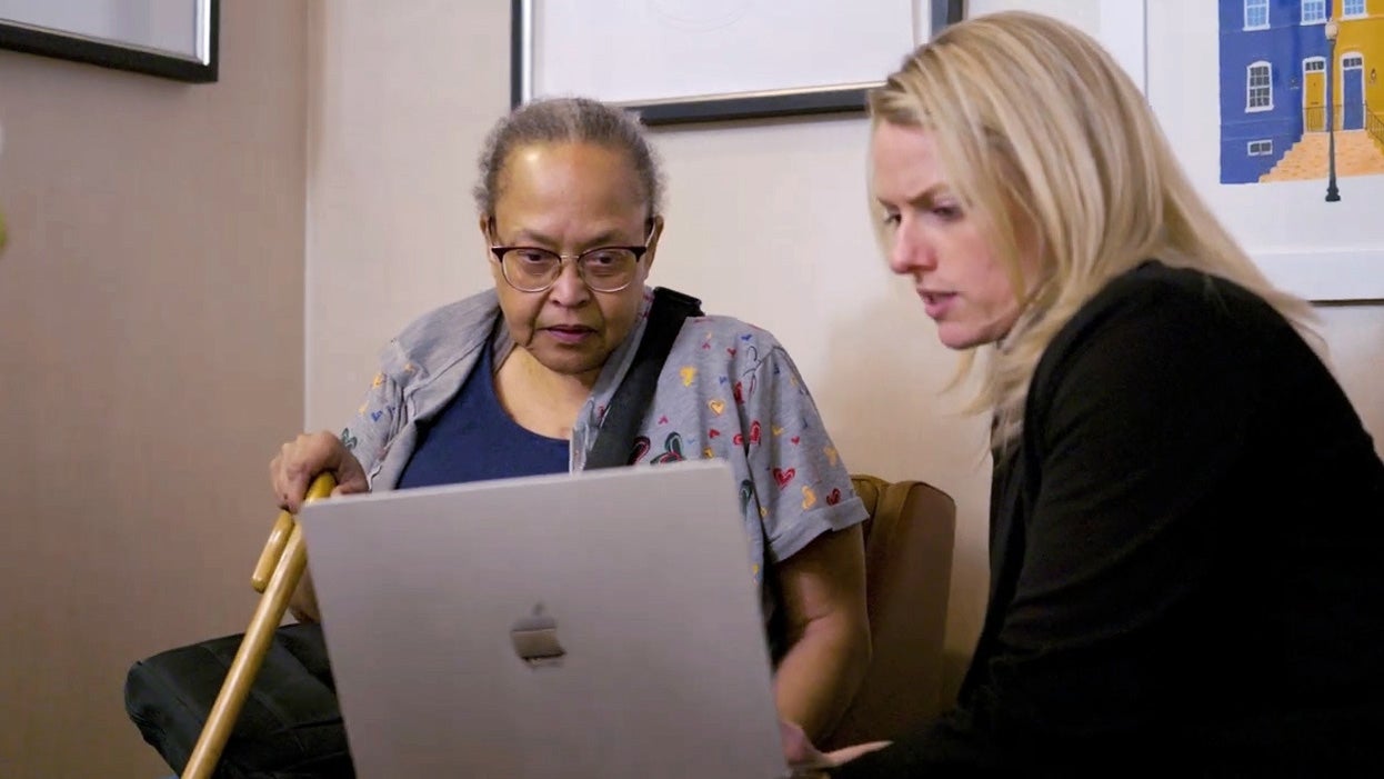 Allison Dowling and a patient consult a laptop