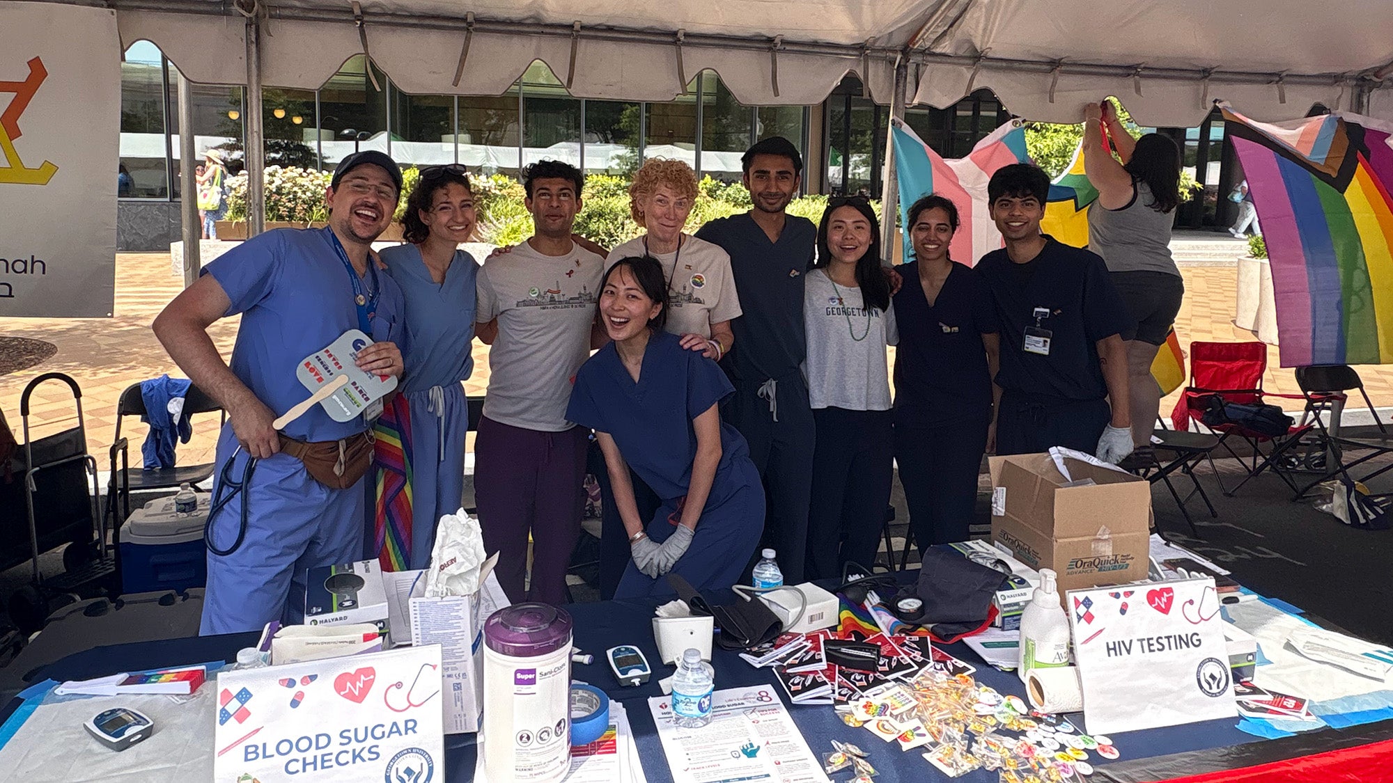 Student volunteers stand behind their table at the Capital Pride Festival