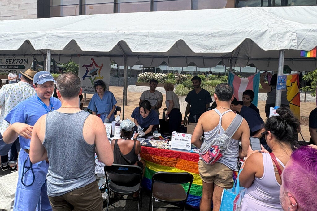 Students administer screenings to Capital Pride Festival attendees, while some attendees look on