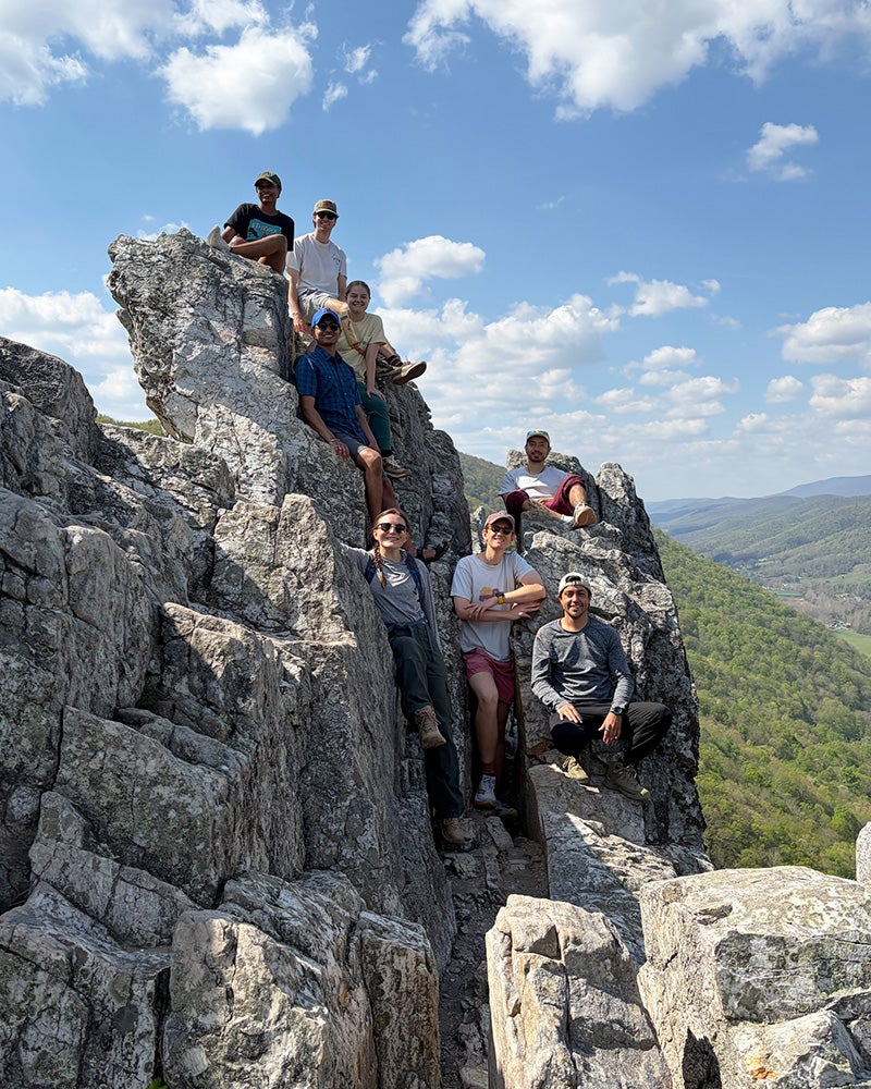 Participants in the Wilderness Medicine course perch on a rock outcrop in the mountains of West Virginia