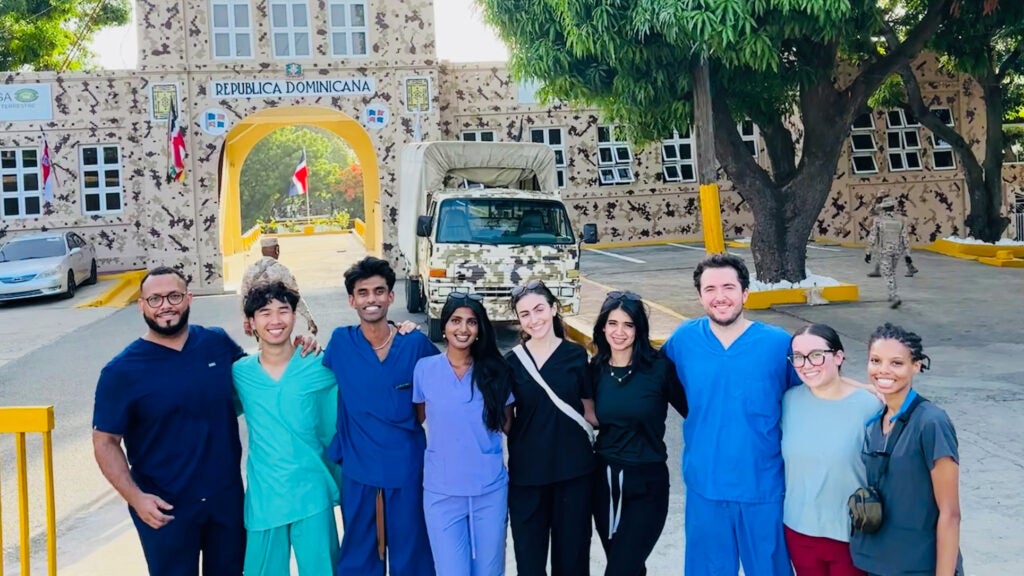 A group of medical students stands together before a border crossing in the Dominican Republic