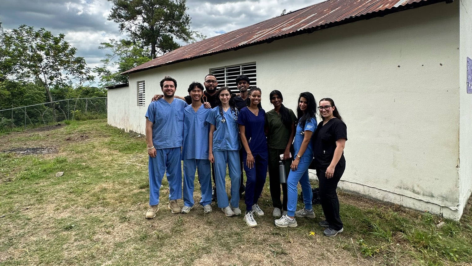 A group of medical students stands together near a building in the Dominican Republic