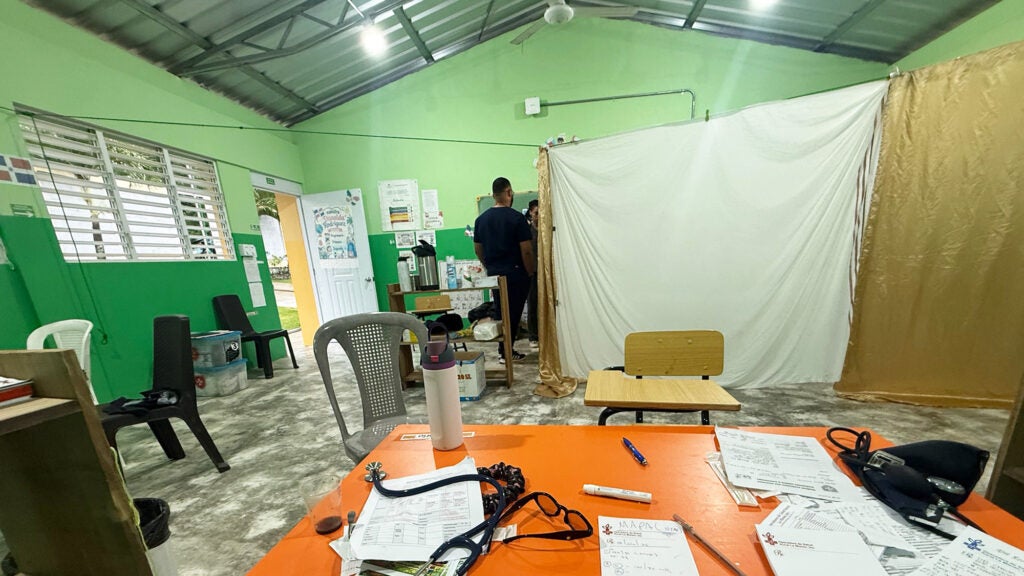 A large room being subdivided by temporary dividers made of sheets hung from clotheslines