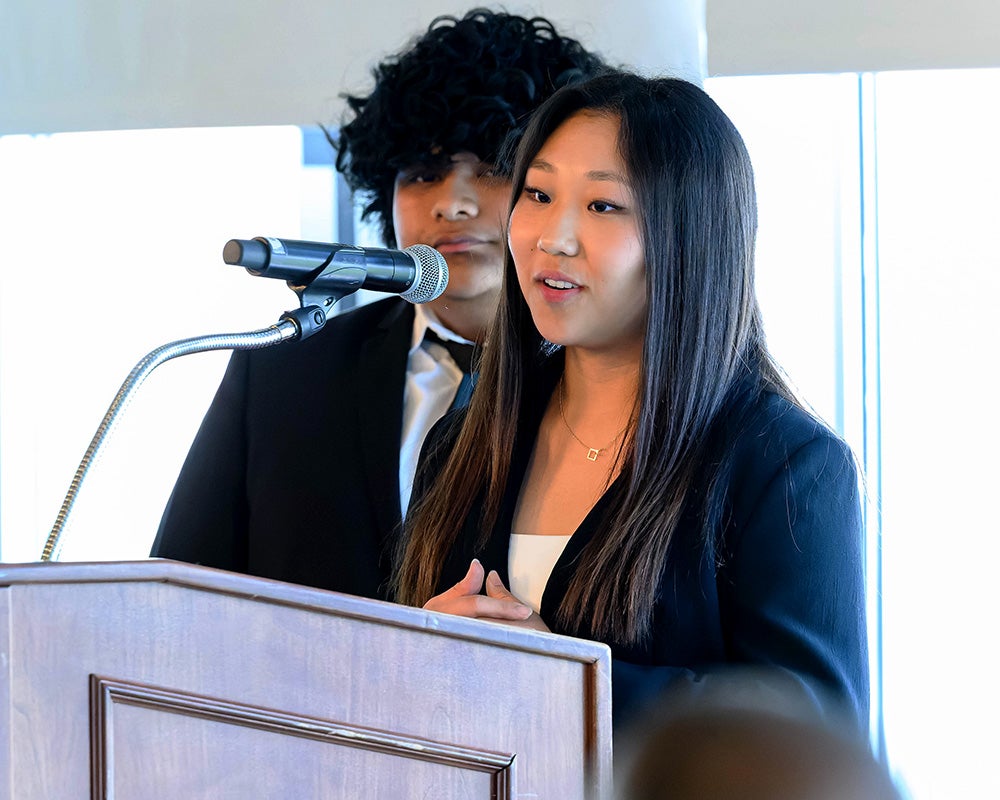 Two students stand behind a podium