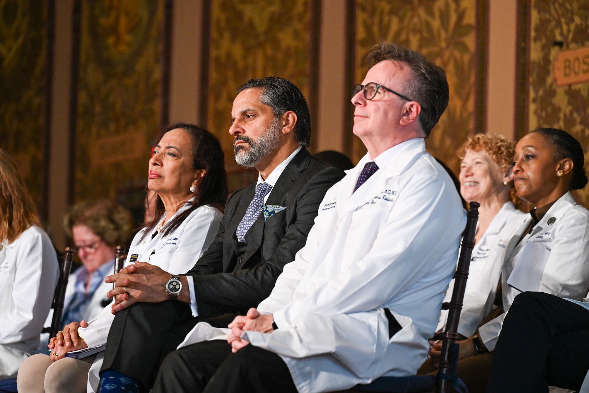 Dr. Beauchamp, President Penalver and other faculty sit onstage in Gaston Hall during the ceremony